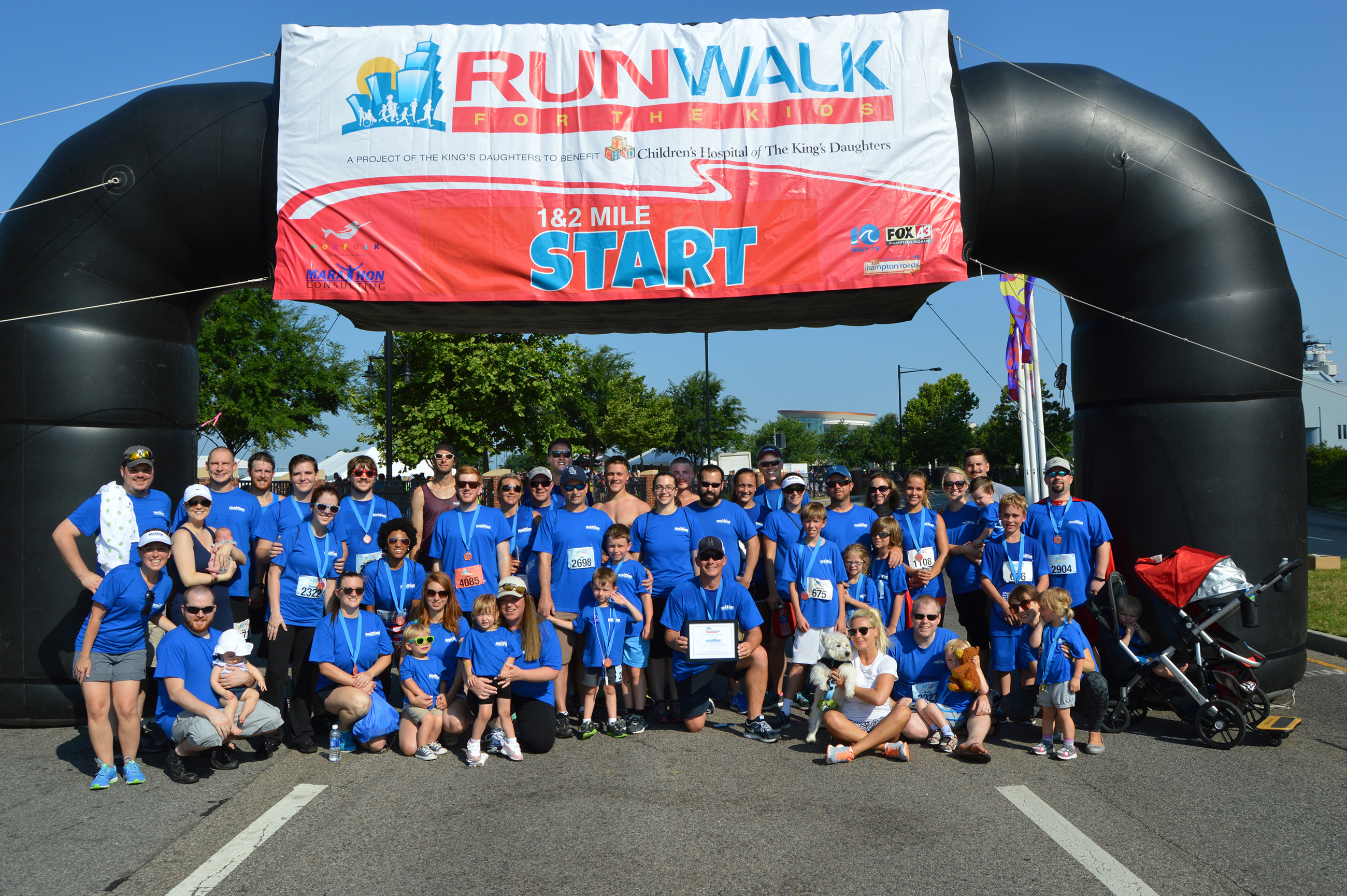 Racers pose in front of RunWalk starting line